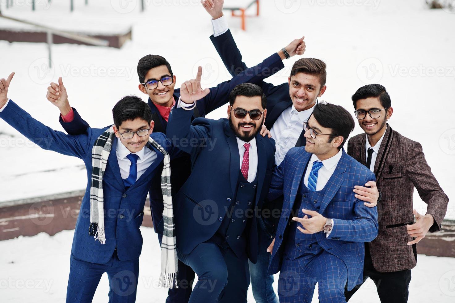 Group of six indian businessman in suits posed outdoor in winter day at Europe, hugs and happy emotions. photo