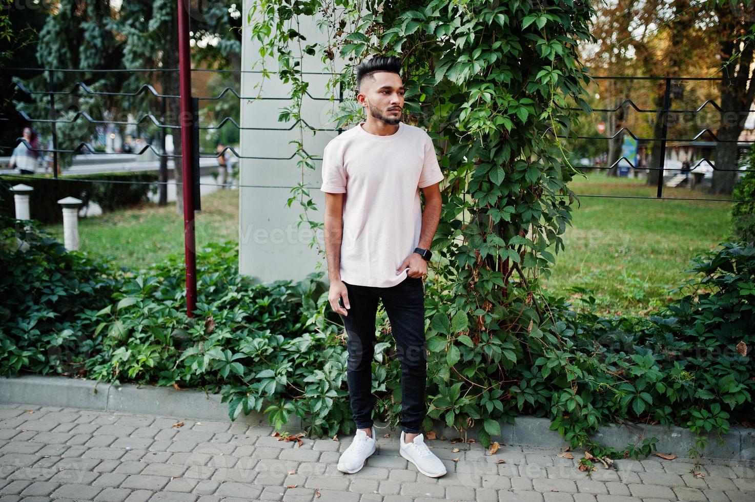 Stylish indian beard man at pink t-shirt. India model posed outdoor at streets of city. photo