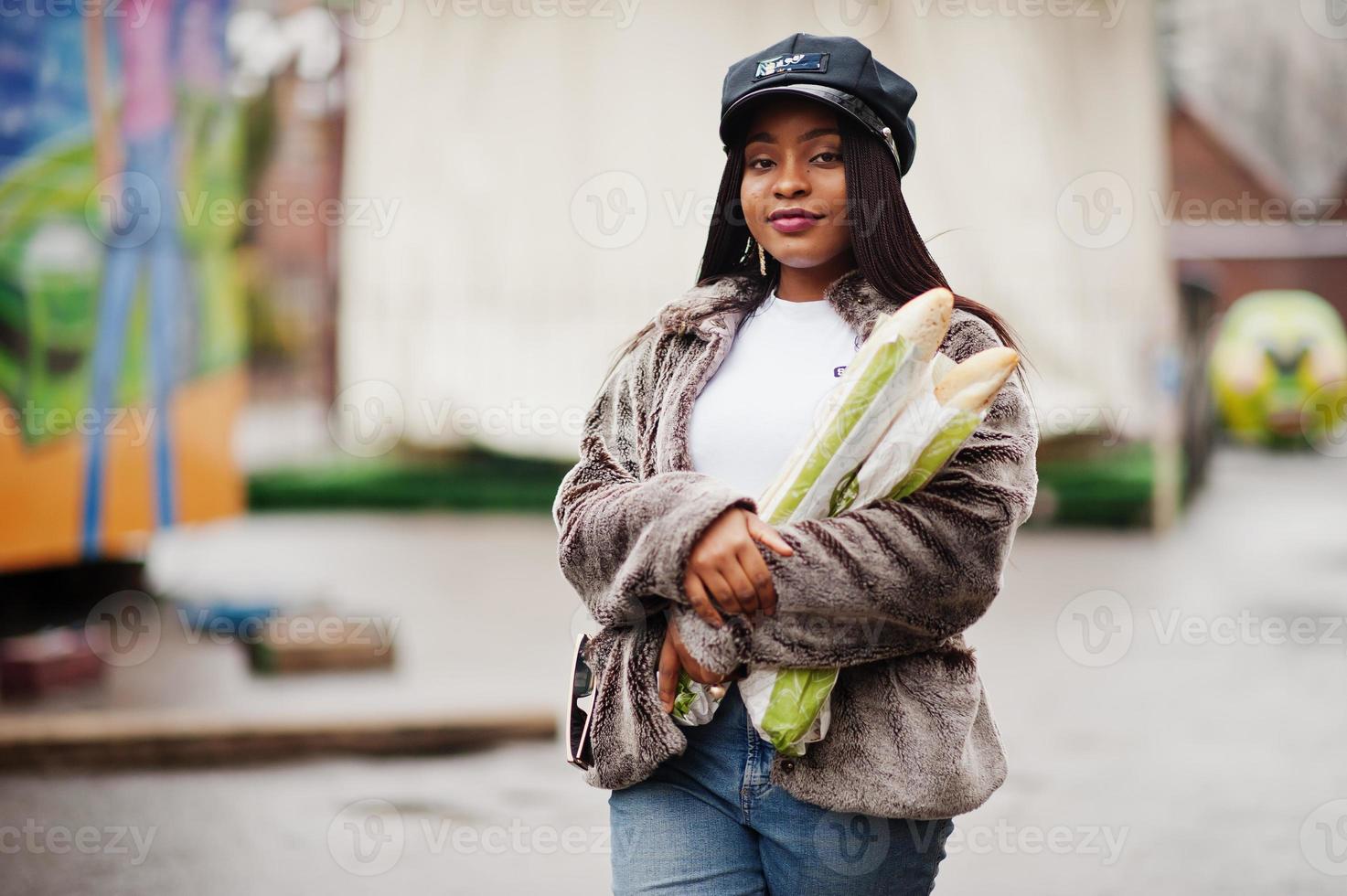 mujer afroamericana de moda con gorra negra y piel con dos rollos de  baguette en las manos. 10490690 Foto de stock en Vecteezy