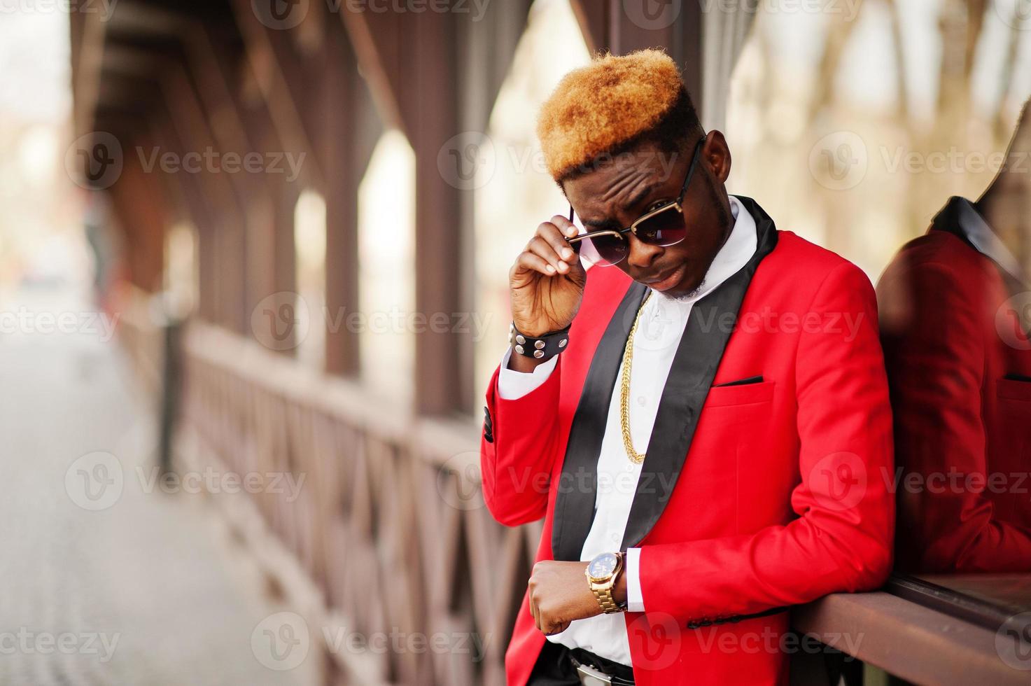 Fashion african american man model at red suit, with highlights hair posed at street. photo