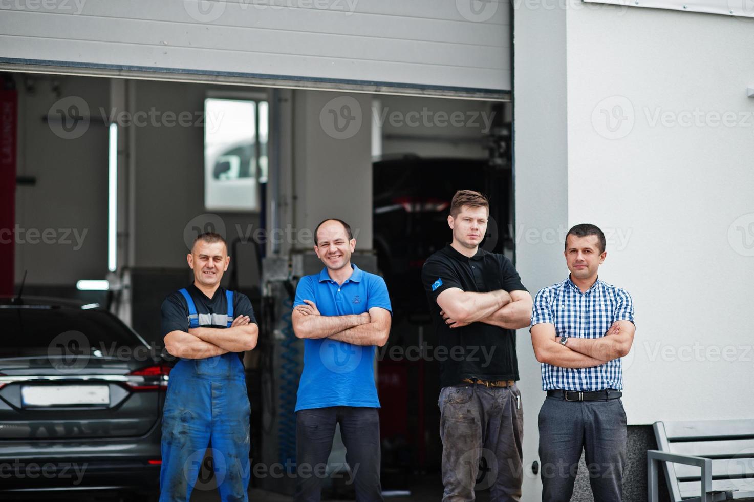 Car repair and maintenance theme. Three mechanic and manager in uniform in auto service. photo