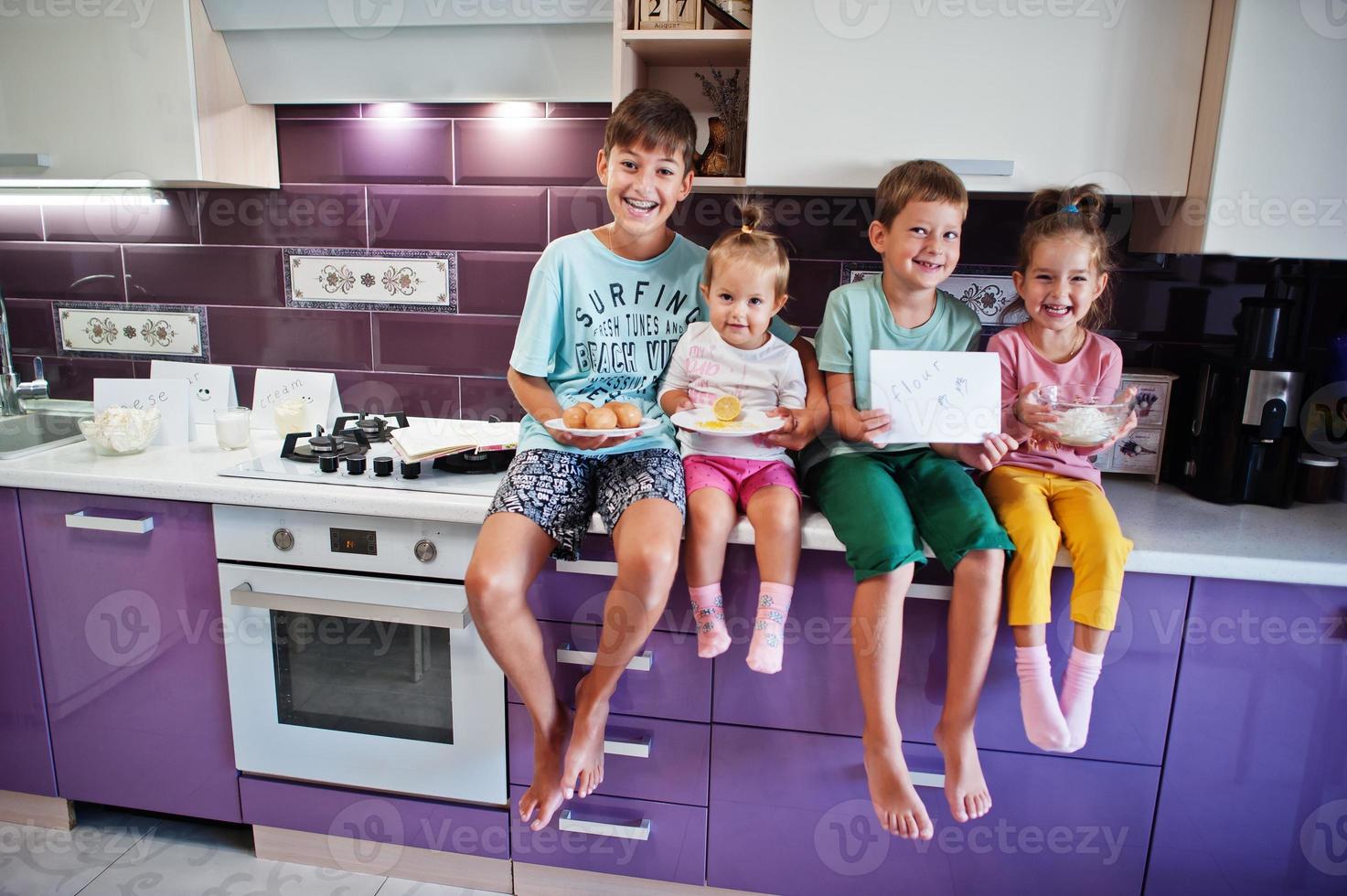 Kids cooking at kitchen, happy children's moments. Four kid, large family. photo