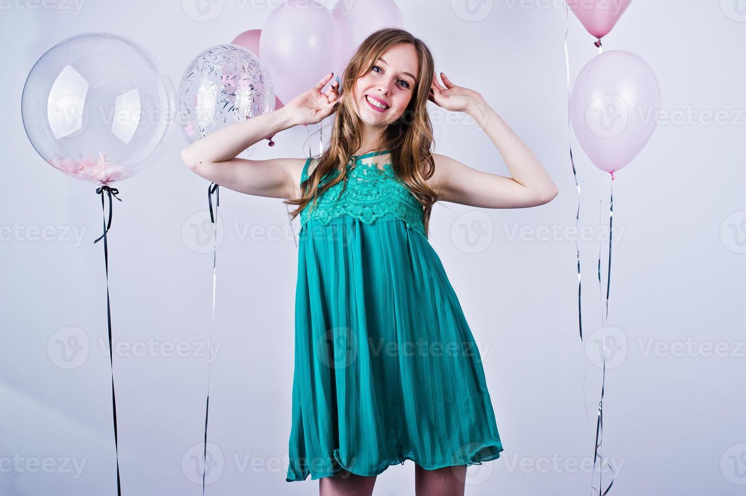 Happy girl in green turqoise dress with colored balloons isolated on white. Celebrating birthday theme. photo