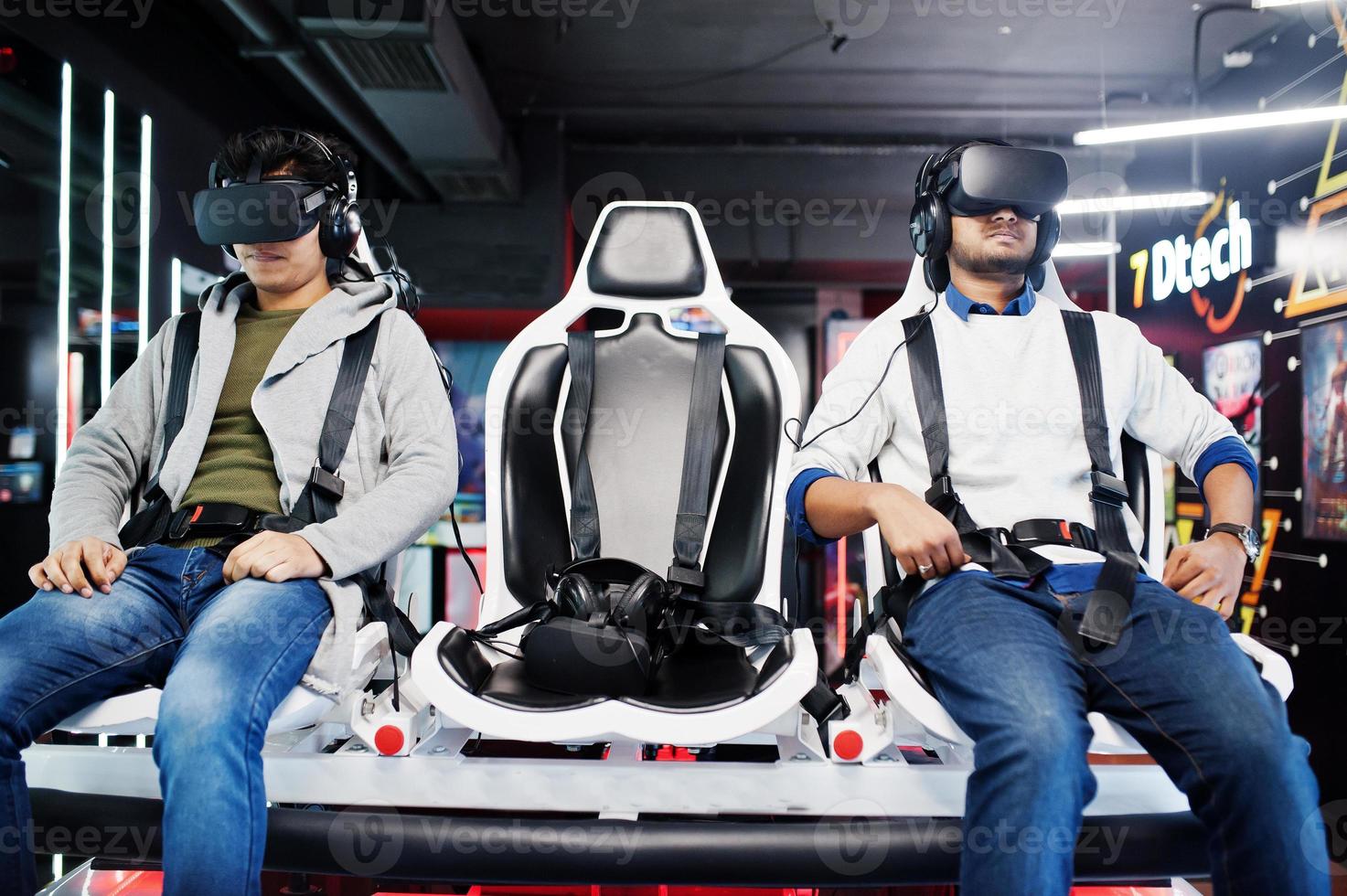 Two young indian people having fun with a new technology of a vr headset at virtual reality simulator. photo