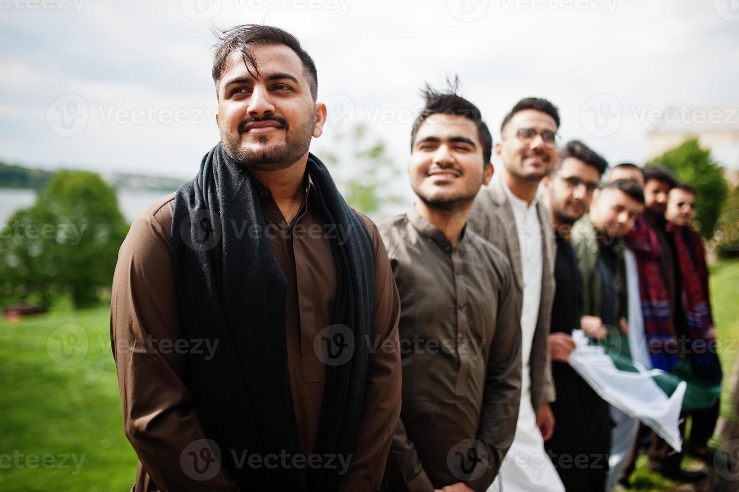 Group of pakistani man wearing traditional clothes salwar kameez or kurta with Pakistan flags. photo
