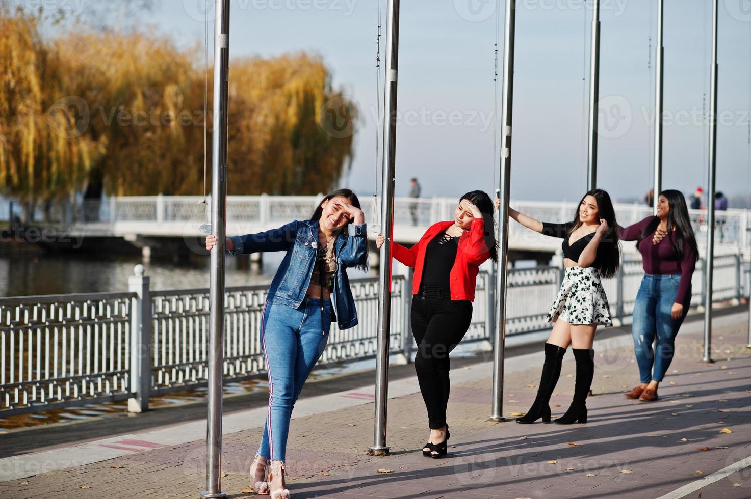 Group of four happy and pretty latino girls from Ecuador posed at street. photo