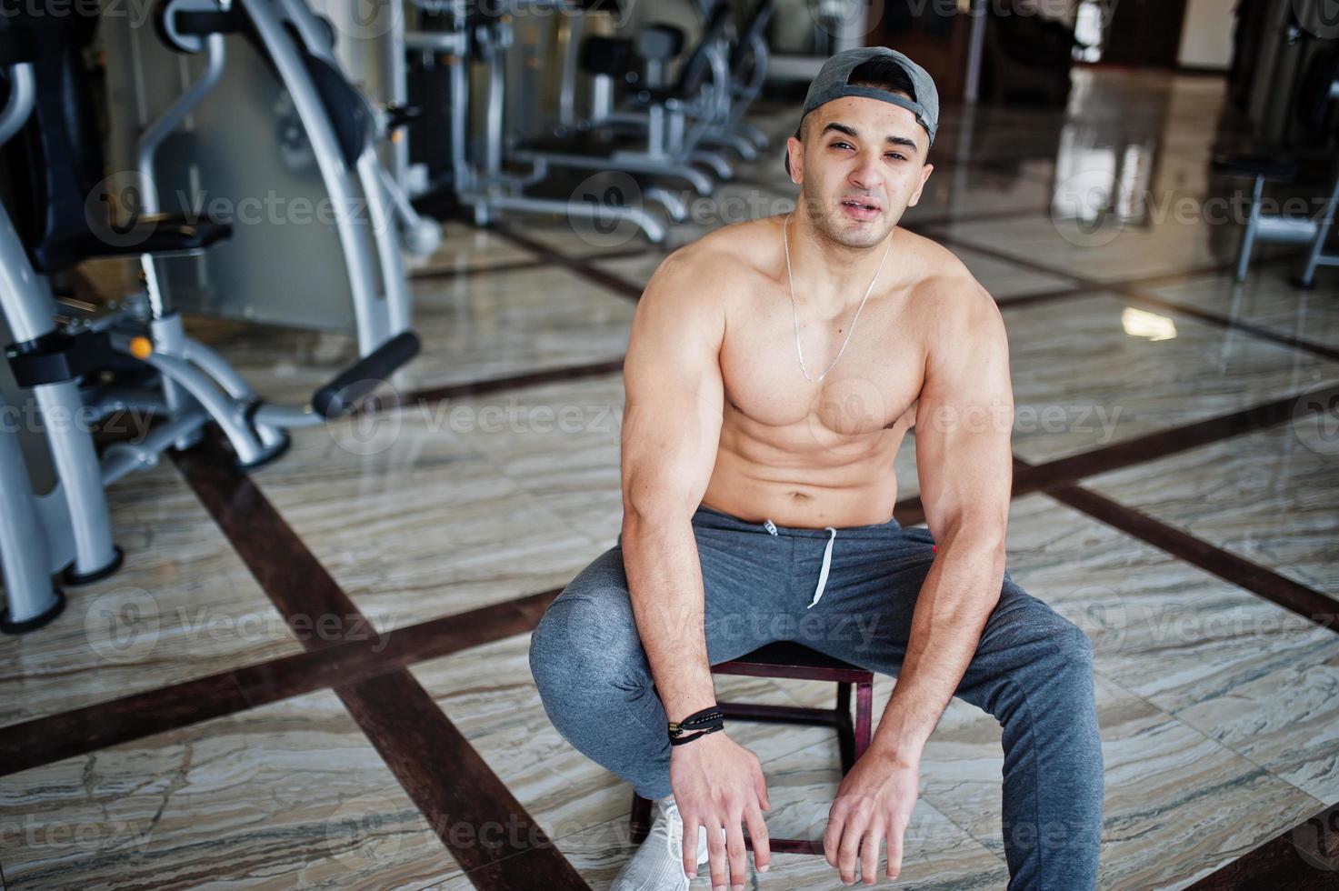 hombre árabe en forma y musculoso haciendo ejercicios en el gimnasio. foto