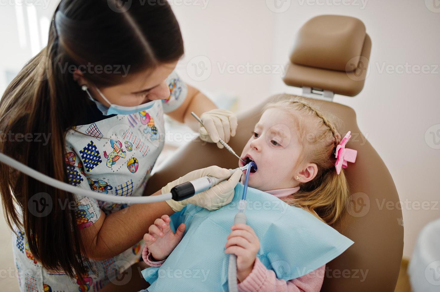 Little baby girl at dentist chair. Children dental. photo