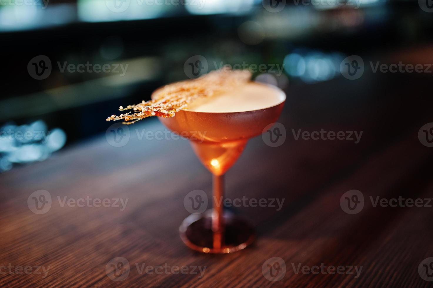 cóctel alcohólico con azúcar fundida en vidrio de bronce en la mesa del bar. foto