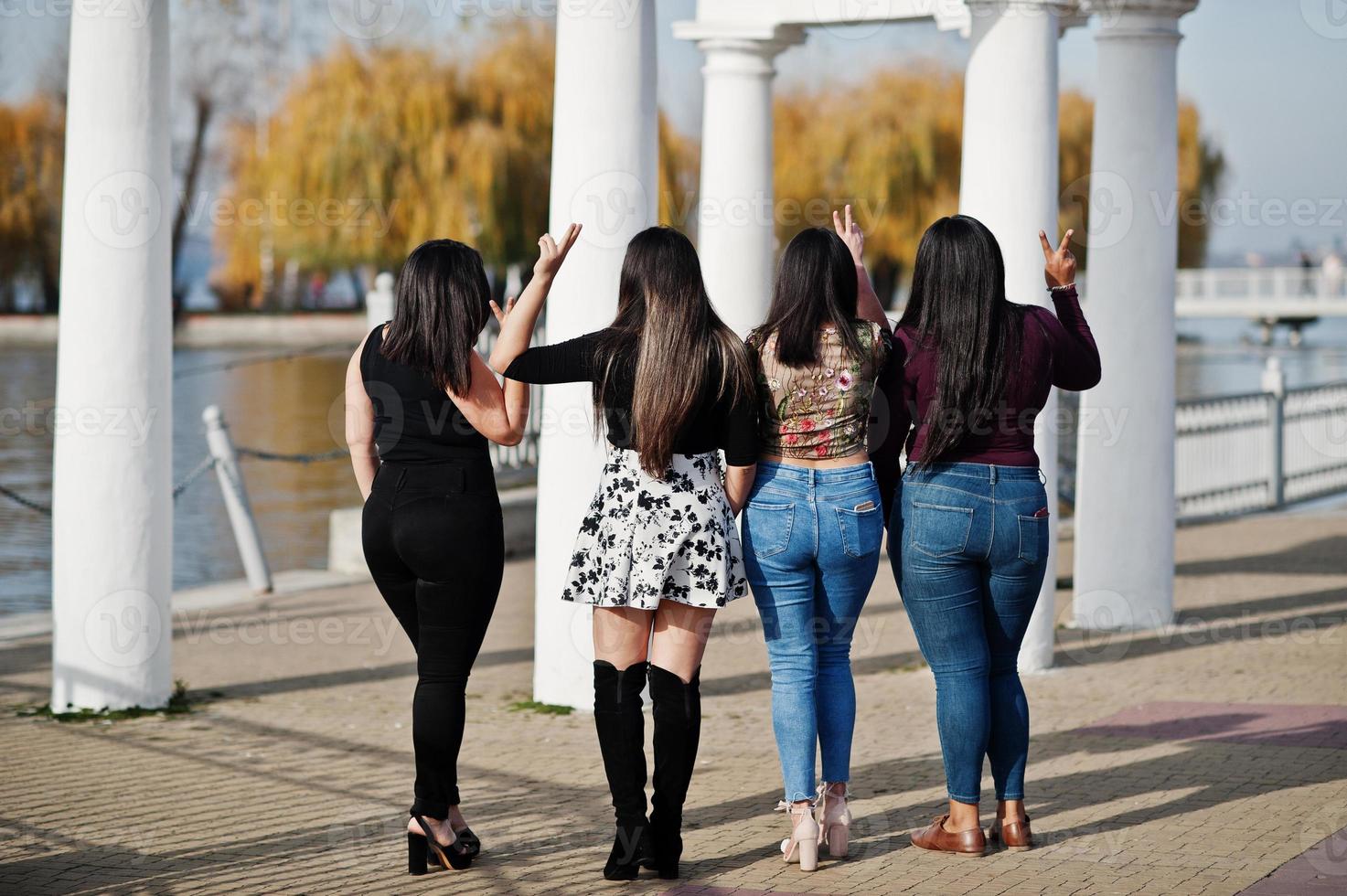 Back of group four happy and pretty latino girls from Ecuador posed at street. photo