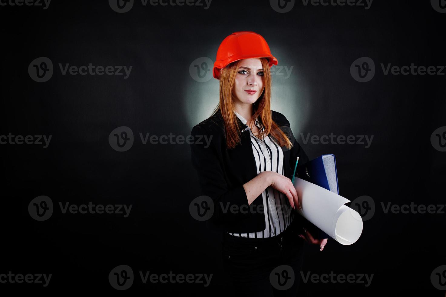 Engineer woman in orange protect helmet with construction paper projekt. photo