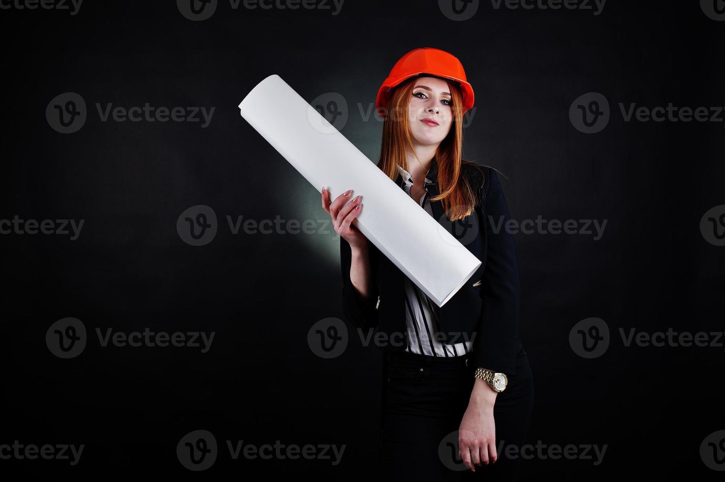 Engineer woman in orange protect helmet with construction paper projekt. photo