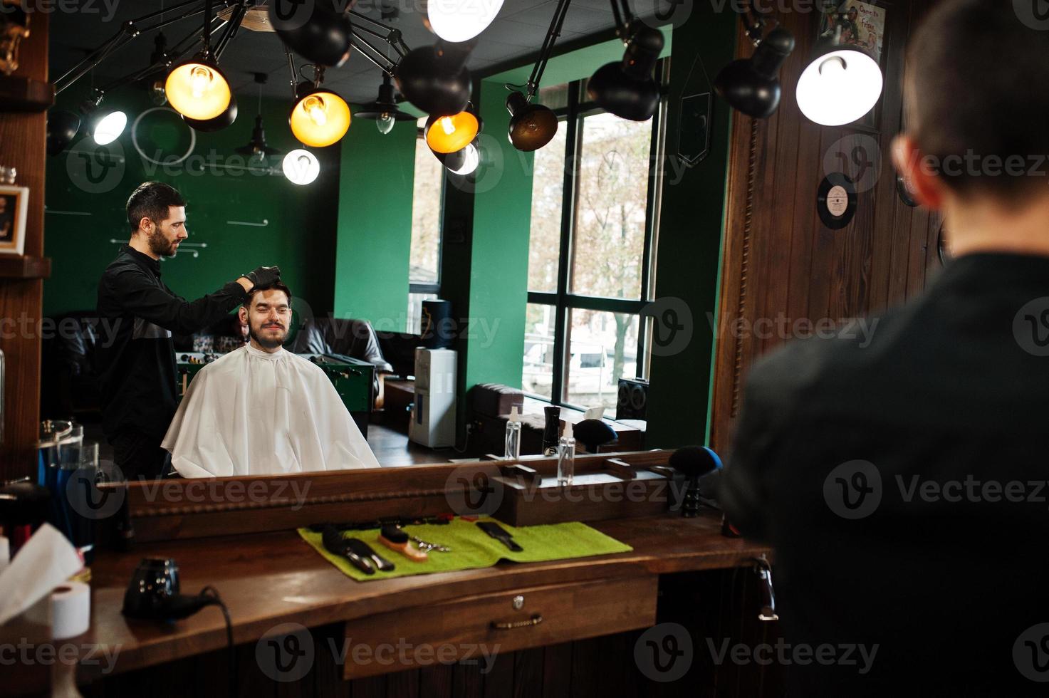 Handsome bearded man at the barbershop, barber at work. photo