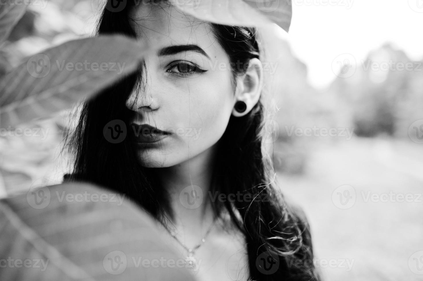 Sensual girl all in black, red lips and earlobe piersing. Goth dramatic woman. Black and white portrait. photo