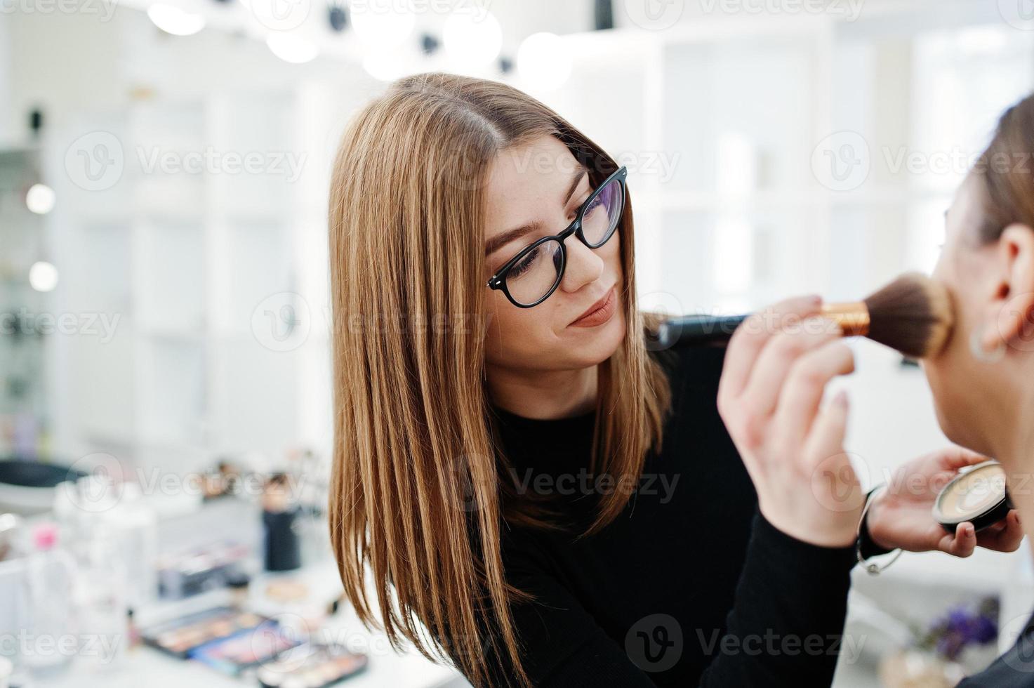 maquilladora trabaja en su salón de estudio de rostro de belleza. mujer solicitando por maestro de maquillaje profesional. concepto de club de belleza. foto