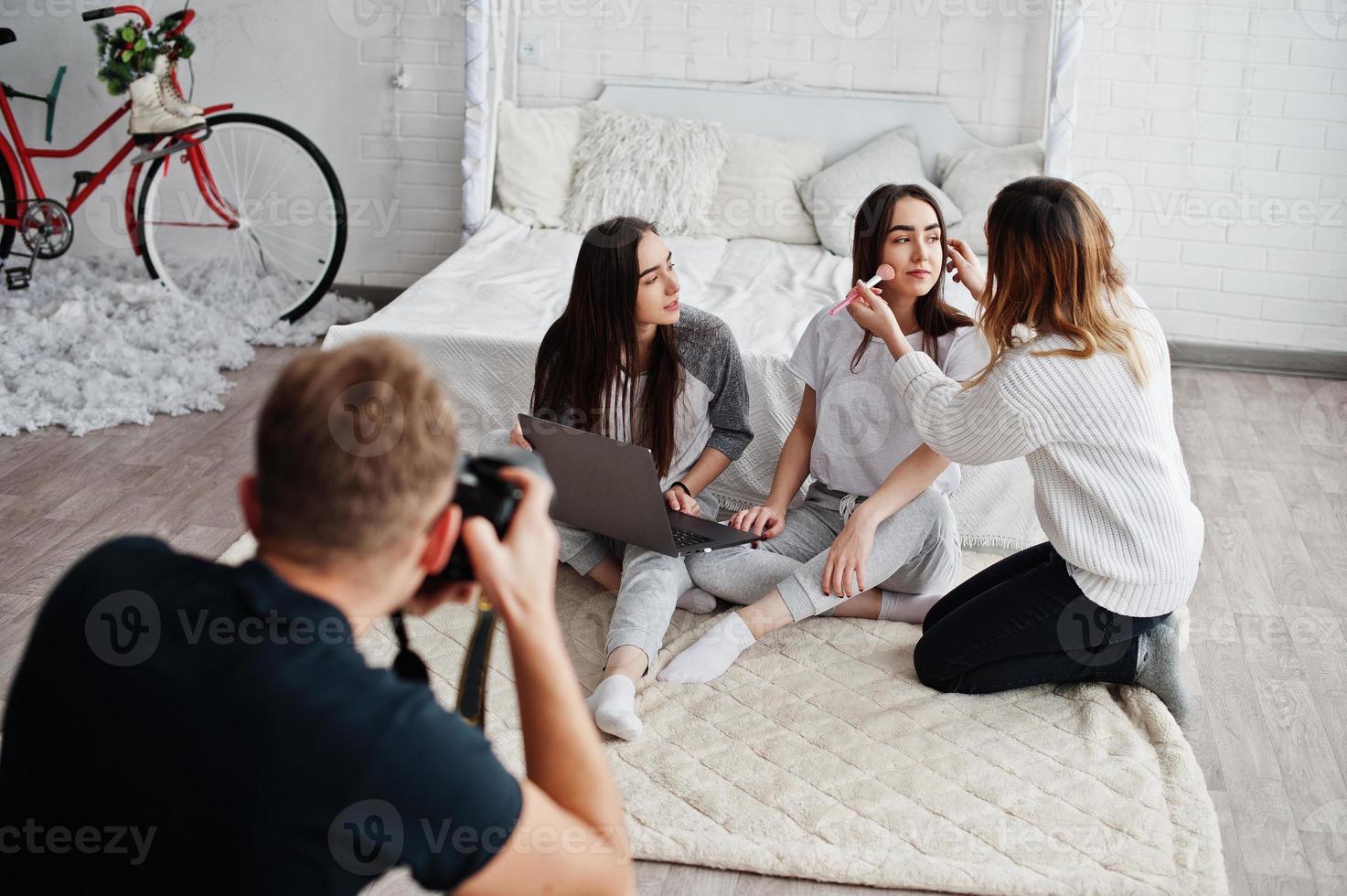 Make up artist prepare two twins models with laptop on studio before photoshoot. Photographer shooting. Teamwork together. photo