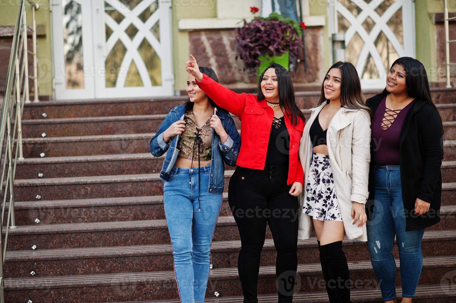 Group of four happy and pretty latino girls from Ecuador posed at street. photo