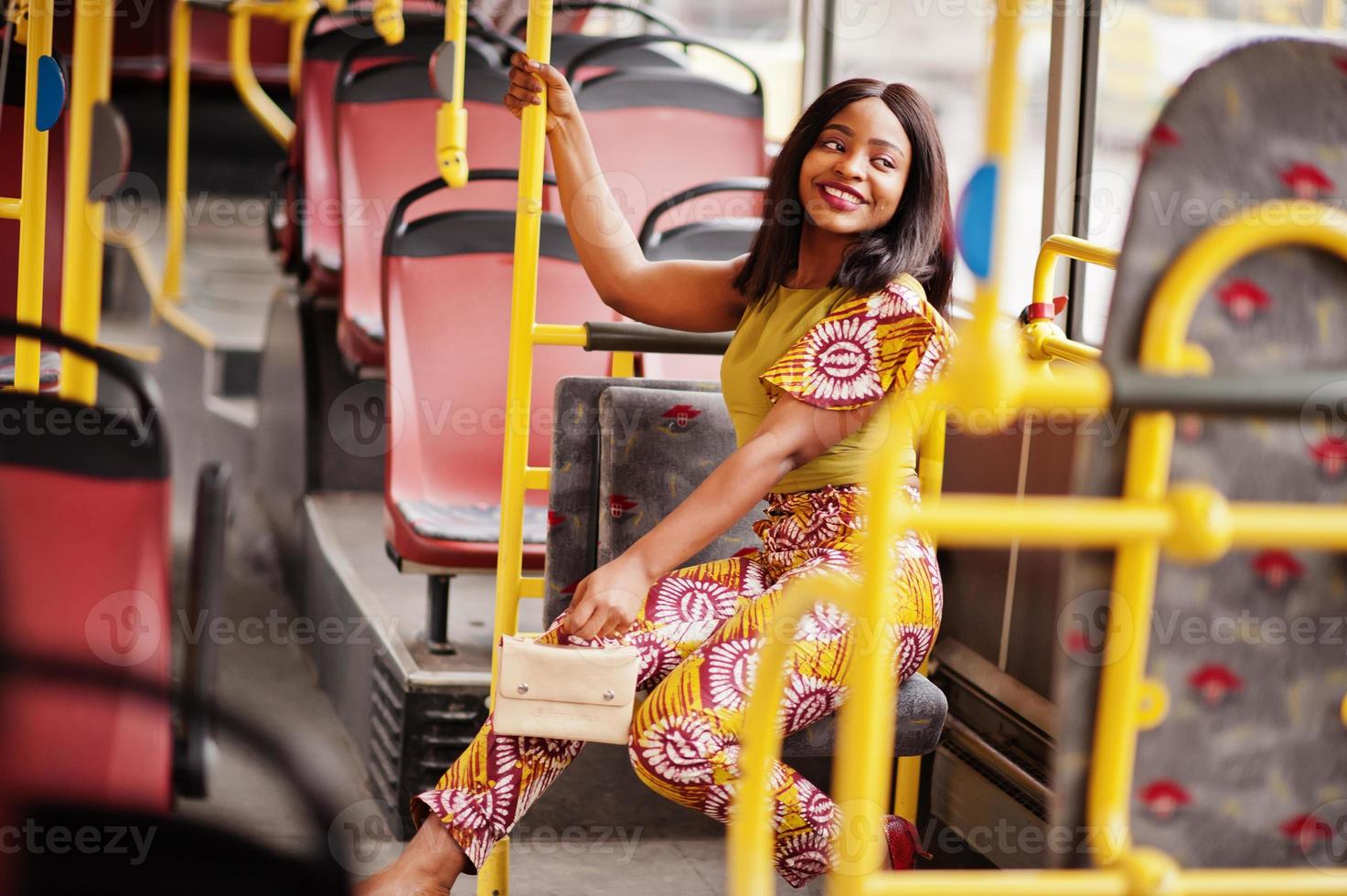 joven mujer afroamericana con estilo montando en un autobús. foto