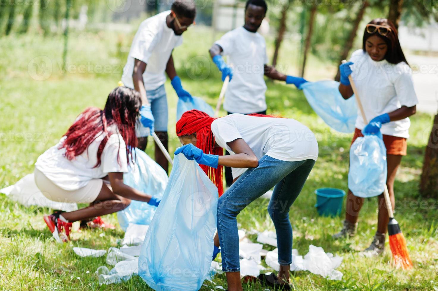 grupo de voluntarios africanos felices con área de limpieza de bolsas de basura en el parque. Concepto de voluntariado, caridad, personas y ecología de África. foto