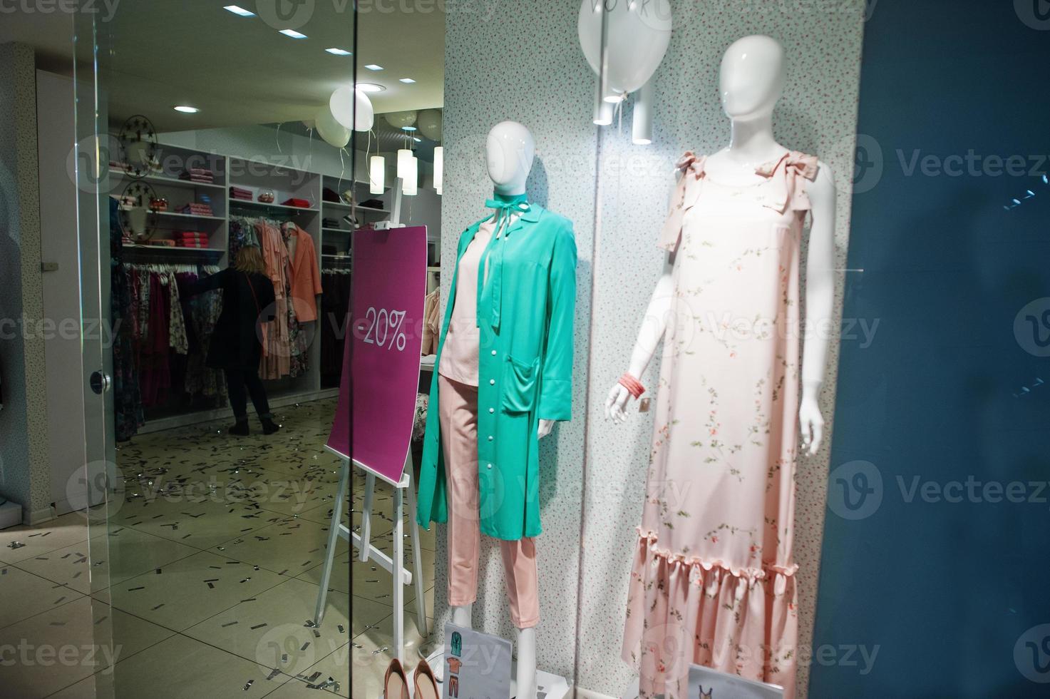 maniquíes en la tienda de ropa colorida femenina nueva boutique moderna con tablero de venta del 20 por ciento. foto