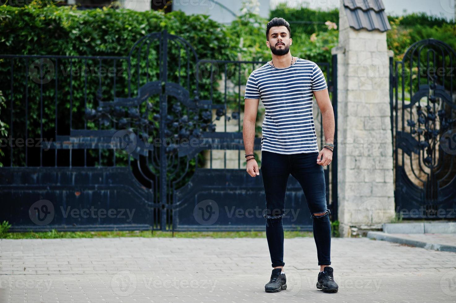 Handsome tall arabian beard man model at stripped shirt posed outdoor. Fashionable arab guy. photo