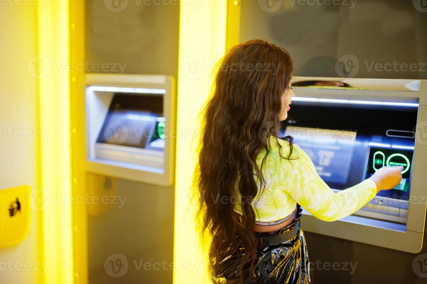 mujer afroamericana retirando dinero de un cajero automático, concepto de cajero automático. foto