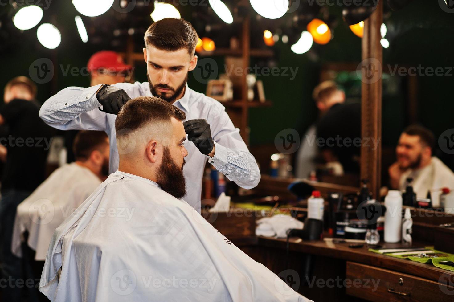 Handsome bearded man at the barbershop, barber at work. photo