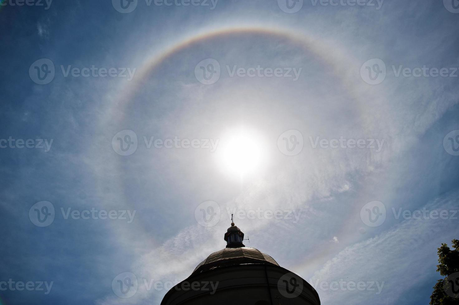 Fantastic beautiful sun halo phenomenon up the church, circular rainbow. photo