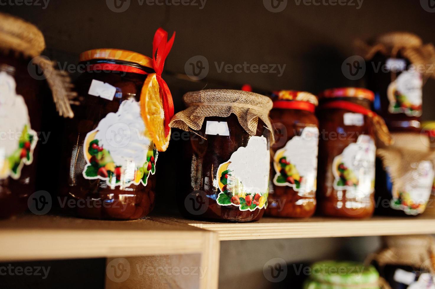 Glass jars with different kinds of jam and berries of a supermarket shelves or grocery store. Homemade canning products. Made with love. photo