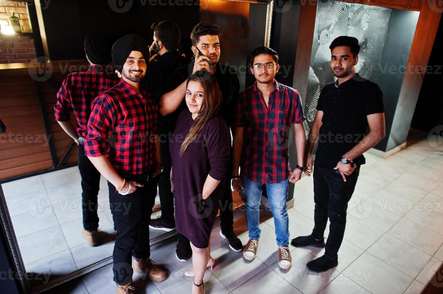 Group of indian friends having fun and rest at night club. photo