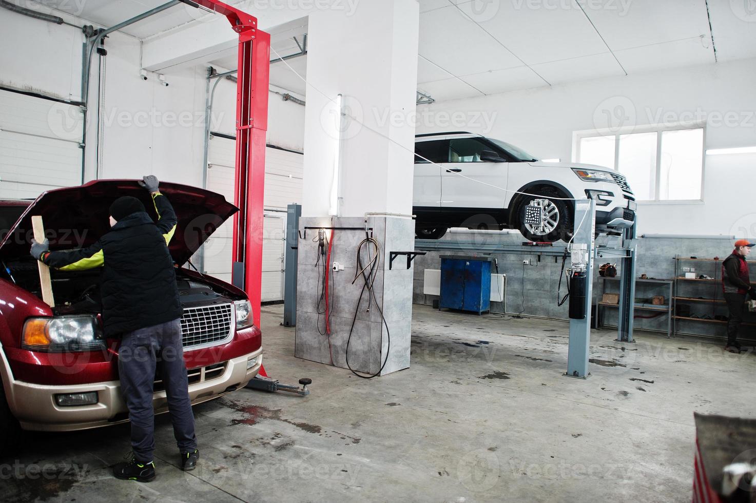 Two american SUV car on stand for wheels alignment camber check in workshop of service station. photo