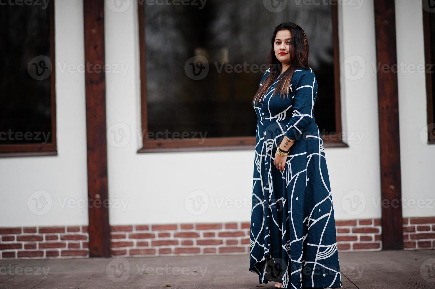 Brunette indian woman in long fashionable dress posed outdoor. photo