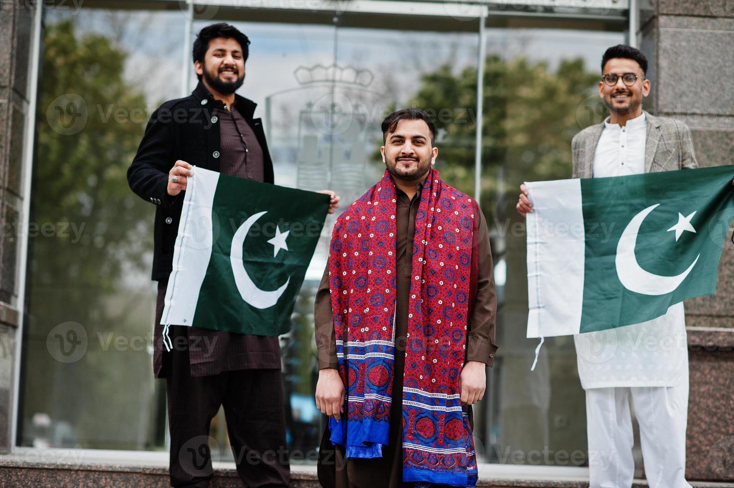 Group of pakistani man wearing traditional clothes salwar kameez or kurta with Pakistan flags. photo