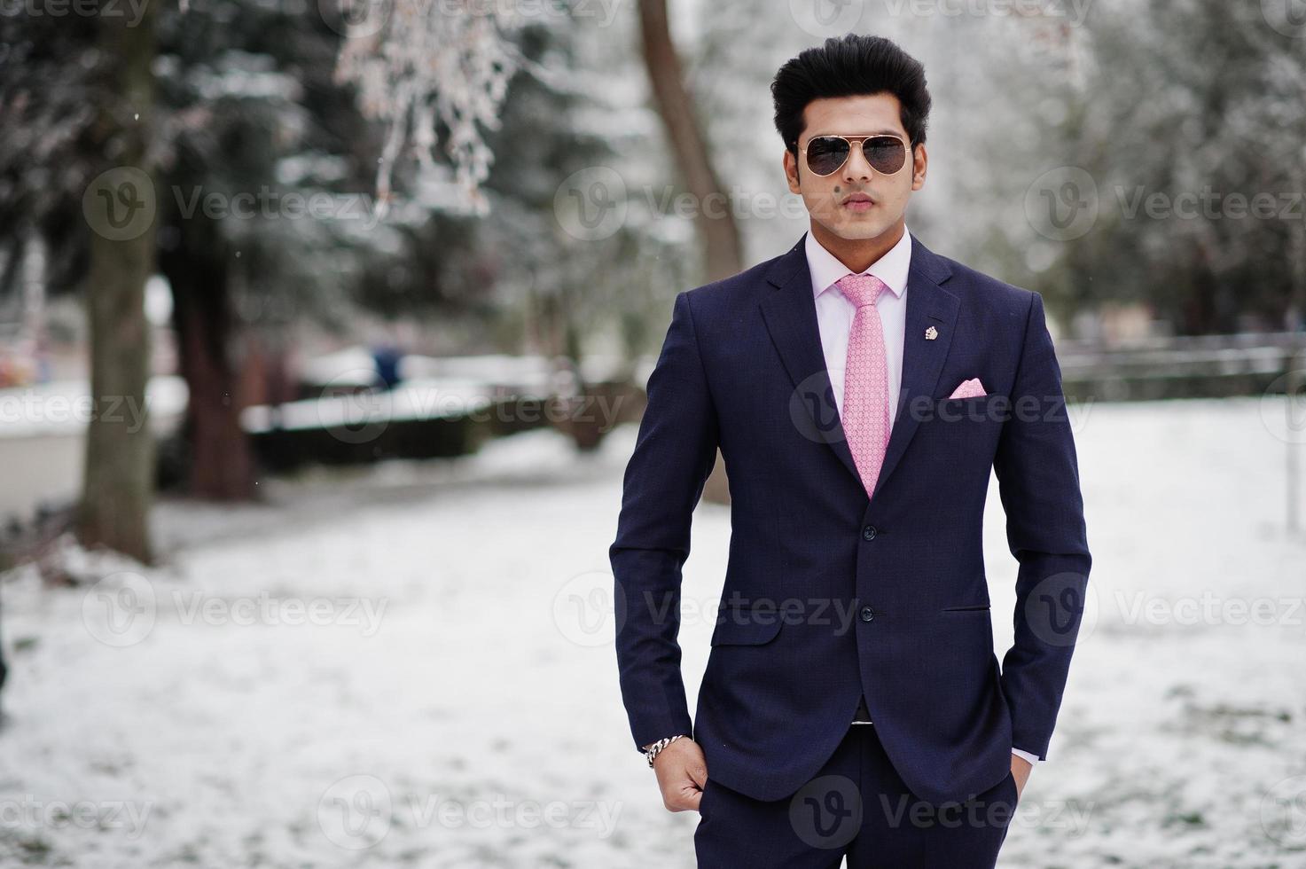 Elegant indian macho man model on suit and pink tie, sunglasses posed on winter day. photo