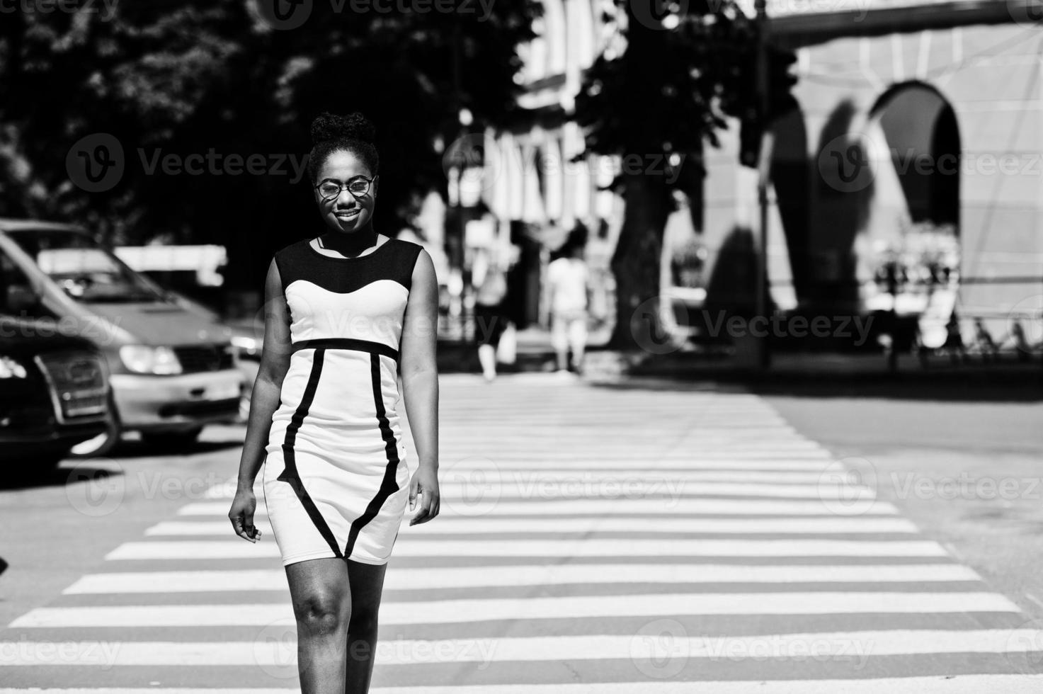 elegante mujer afroamericana caminando en el cruce de peatones o en el paso de peatones. foto