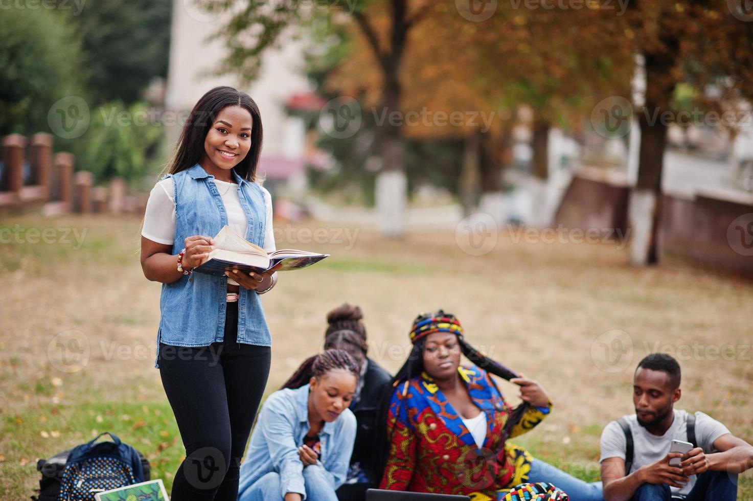 Group of five african college students spending time together on campus at university yard. Black afro friends studying. Education theme. photo