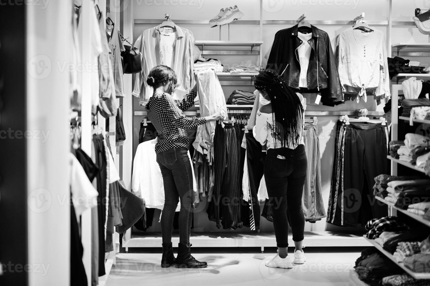 Two african woman choosing clothes at store. Shopping day. photo