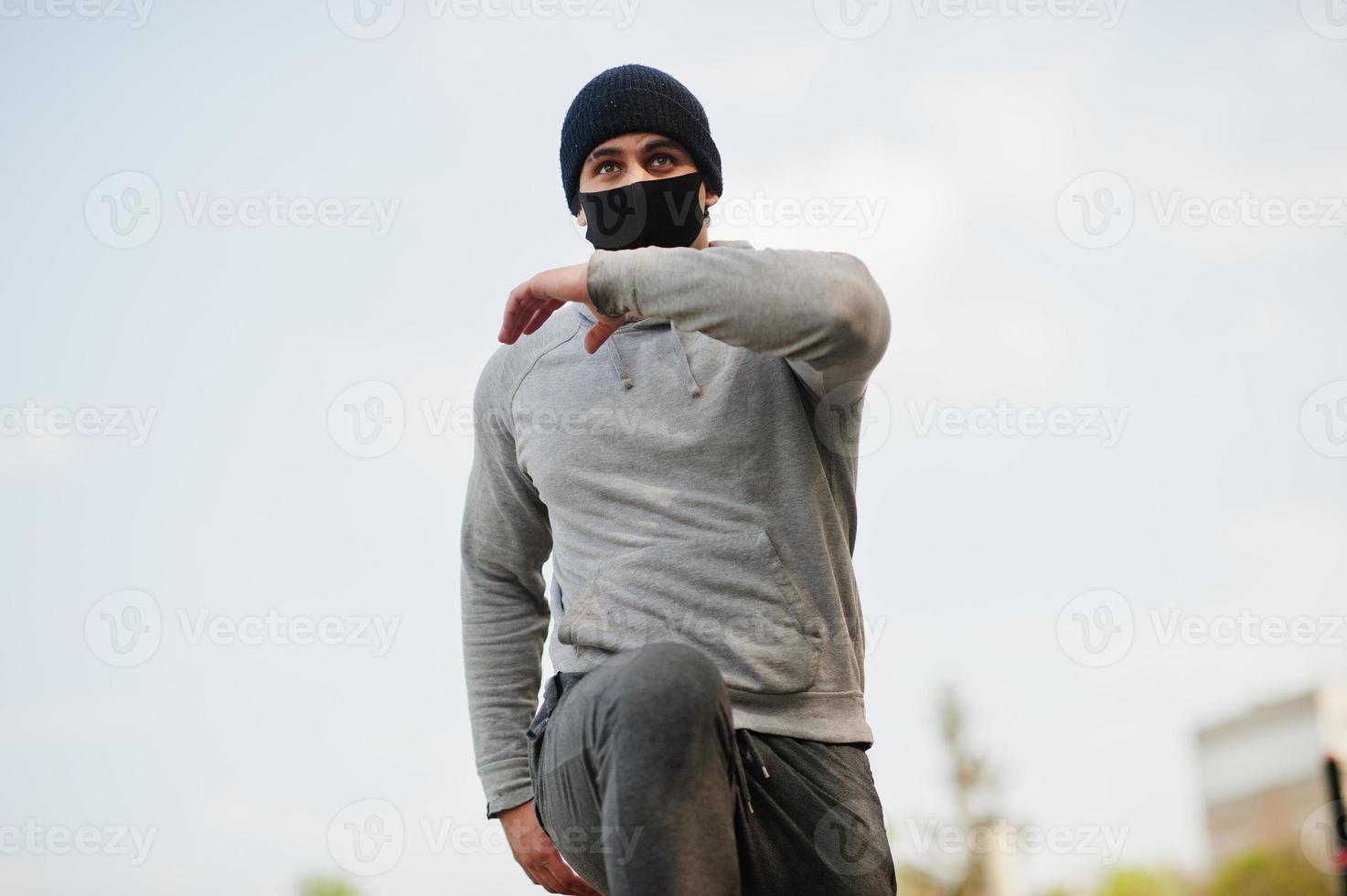 Portrait sports arabian man in black medical face mask run outdoor during coronavirus quarantine. photo