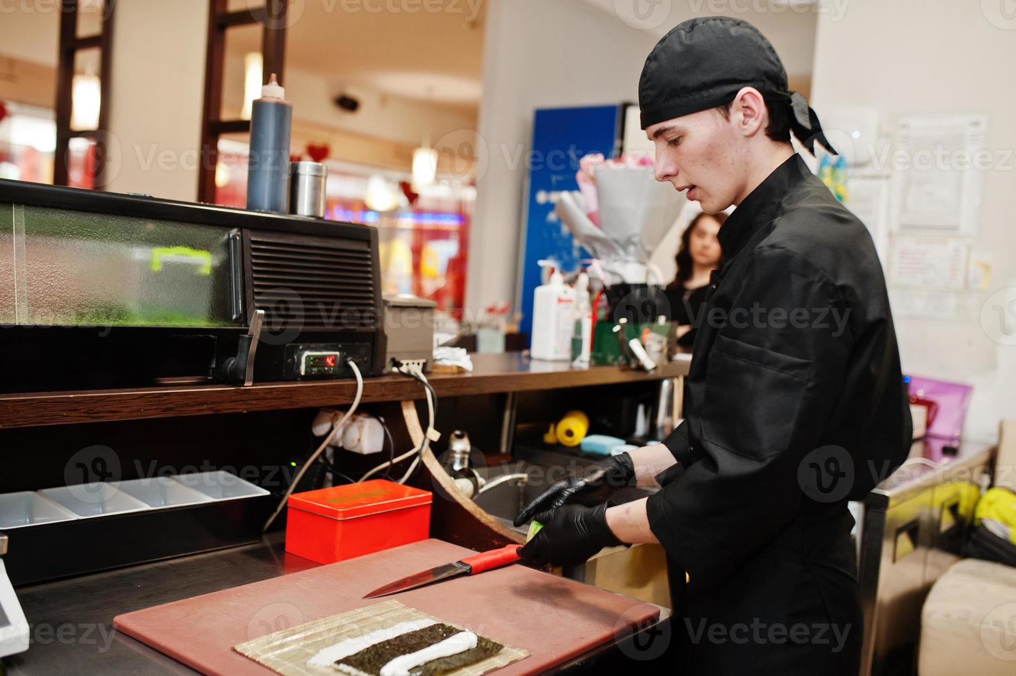Professional chef wear in black making sushi and rolls in a restaurant kitchen of japanese traditional food. photo