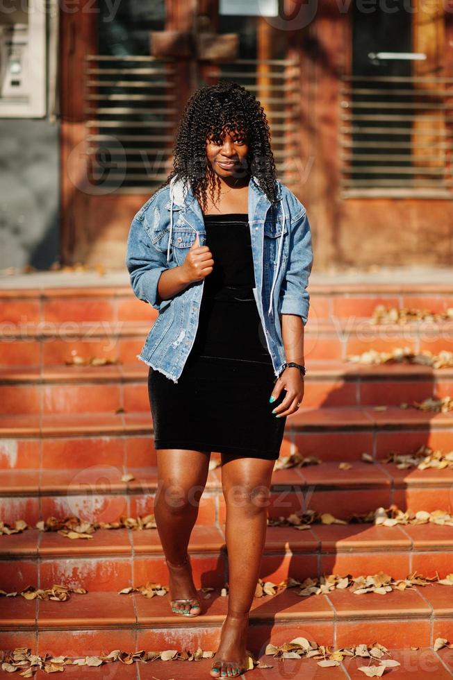 Stylish trendy afro france curly woman posed at autumn day in jeans jacket. Black african female model. photo