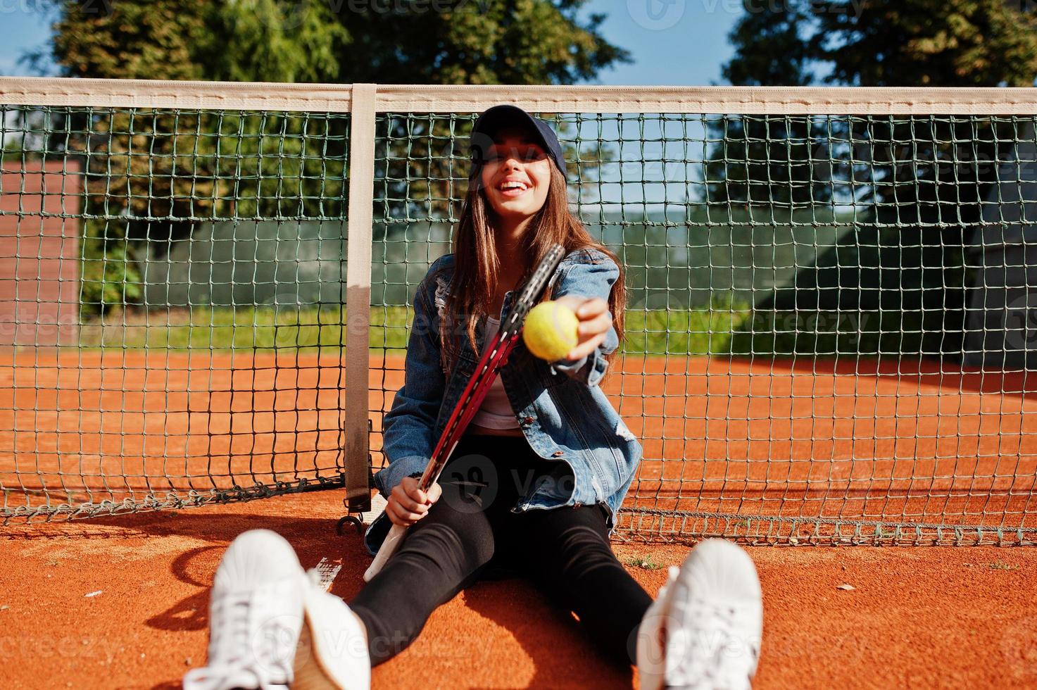 Young sporty girl player with tennis racket on tennis court. photo