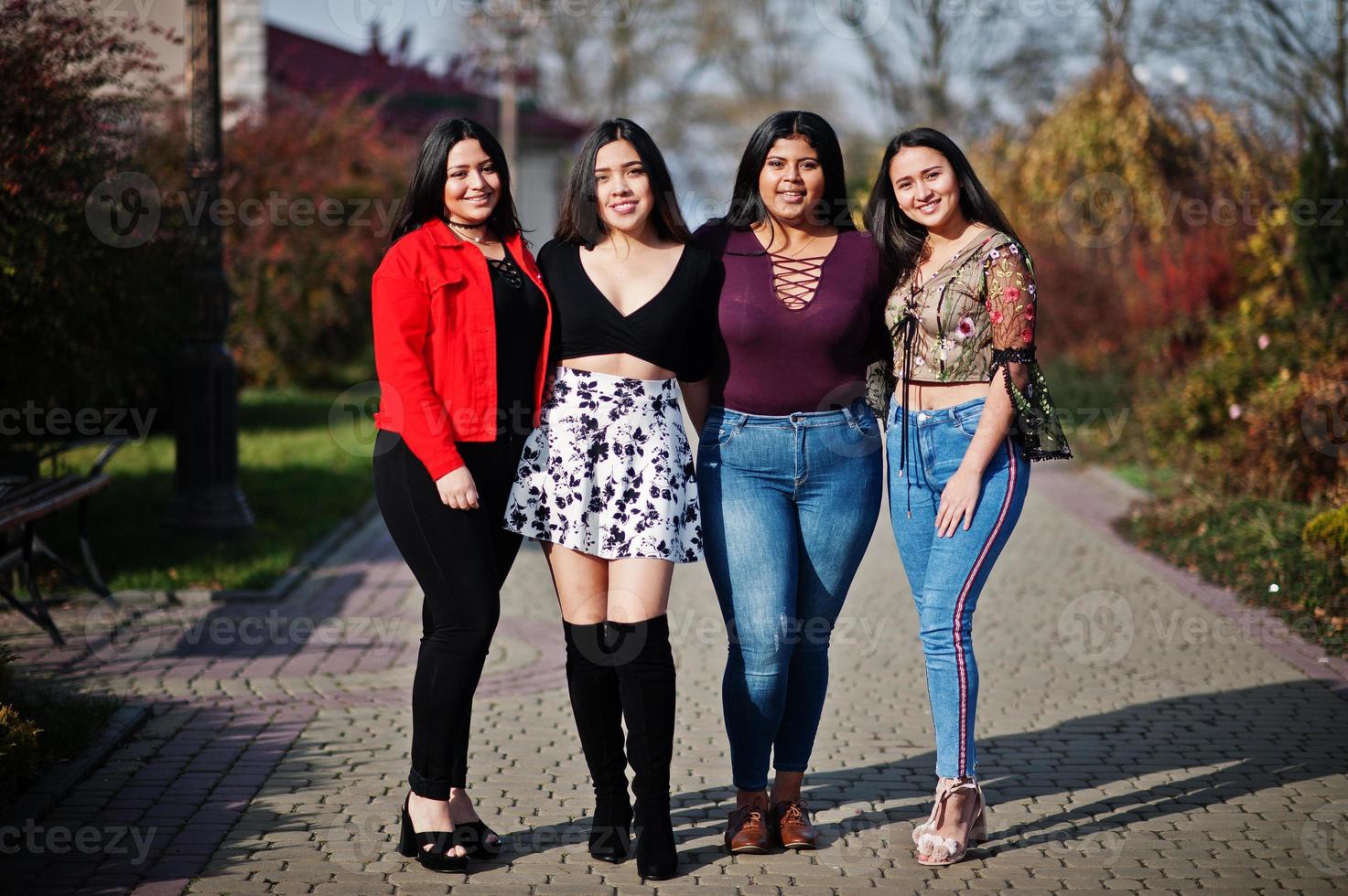 Group of four happy and pretty latino girls from Ecuador posed at street. photo