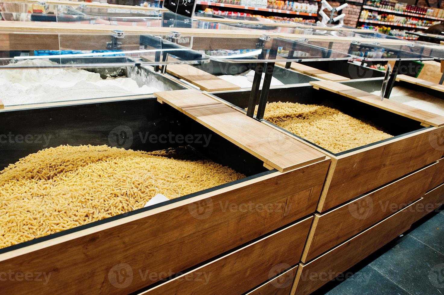 Various cereals and pasta at boxes on supermarket. photo