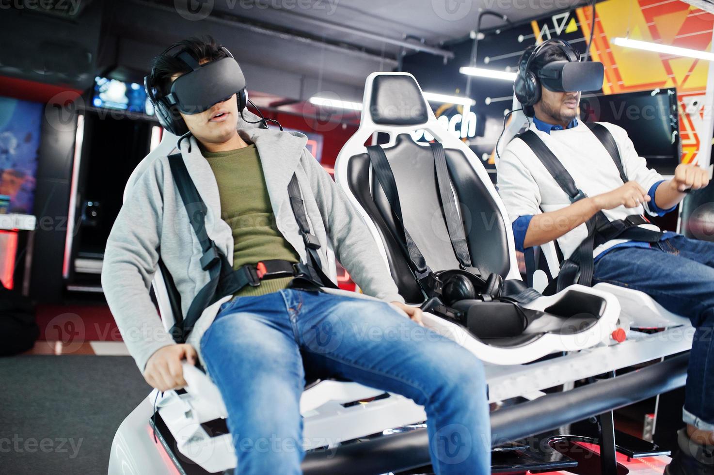 Two young indian people having fun with a new technology of a vr headset at virtual reality simulator. photo