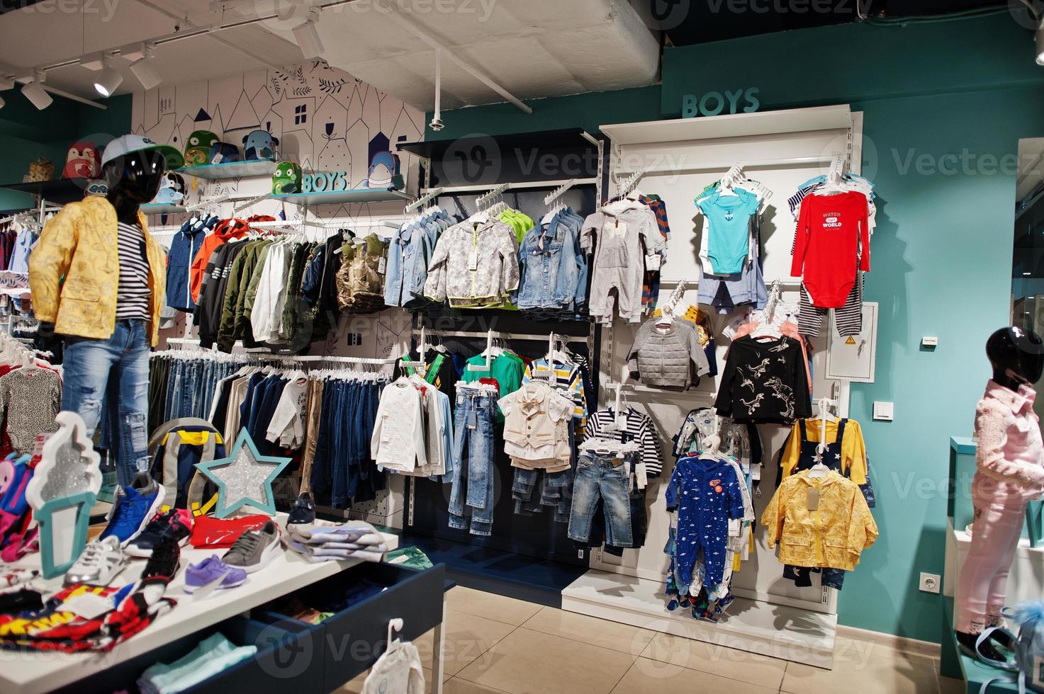 ropa de los niños cuelga en la pantalla de la tienda de ropa para bebés. sección de chicos. 10494851 Foto stock en Vecteezy