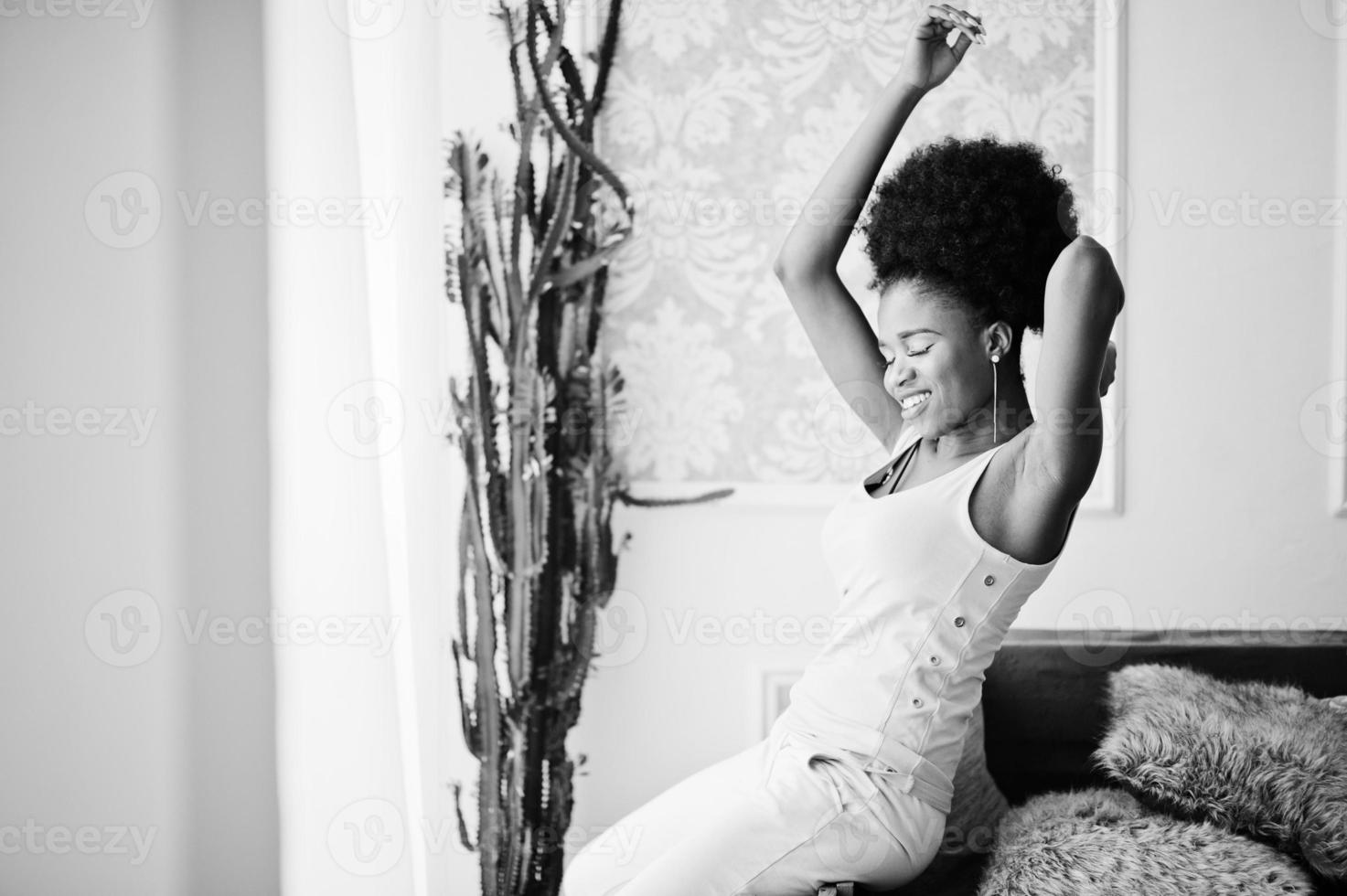 Young african american woman in pink singlet sitting at her room. photo