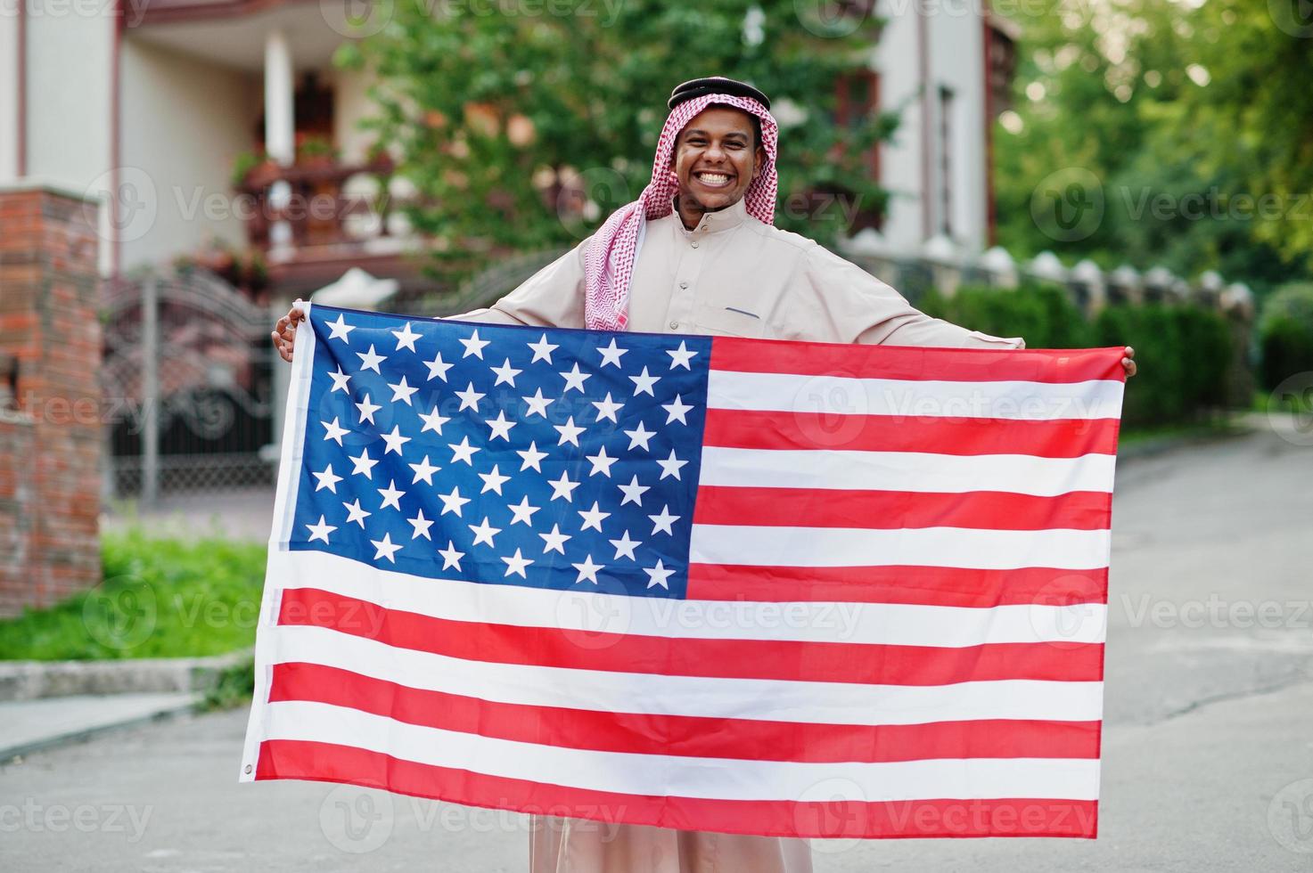 hombre árabe del medio oriente posó en la calle con la bandera de estados unidos. concepto de américa y los países árabes. foto