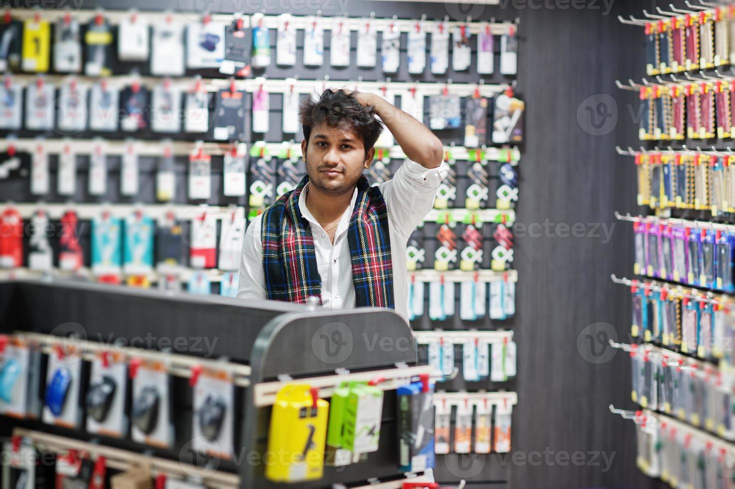 el comprador de un cliente indio en una tienda de teléfonos móviles elige un estuche para su teléfono inteligente. concepto de pueblos y tecnologías del sur de Asia. tienda de celulares foto