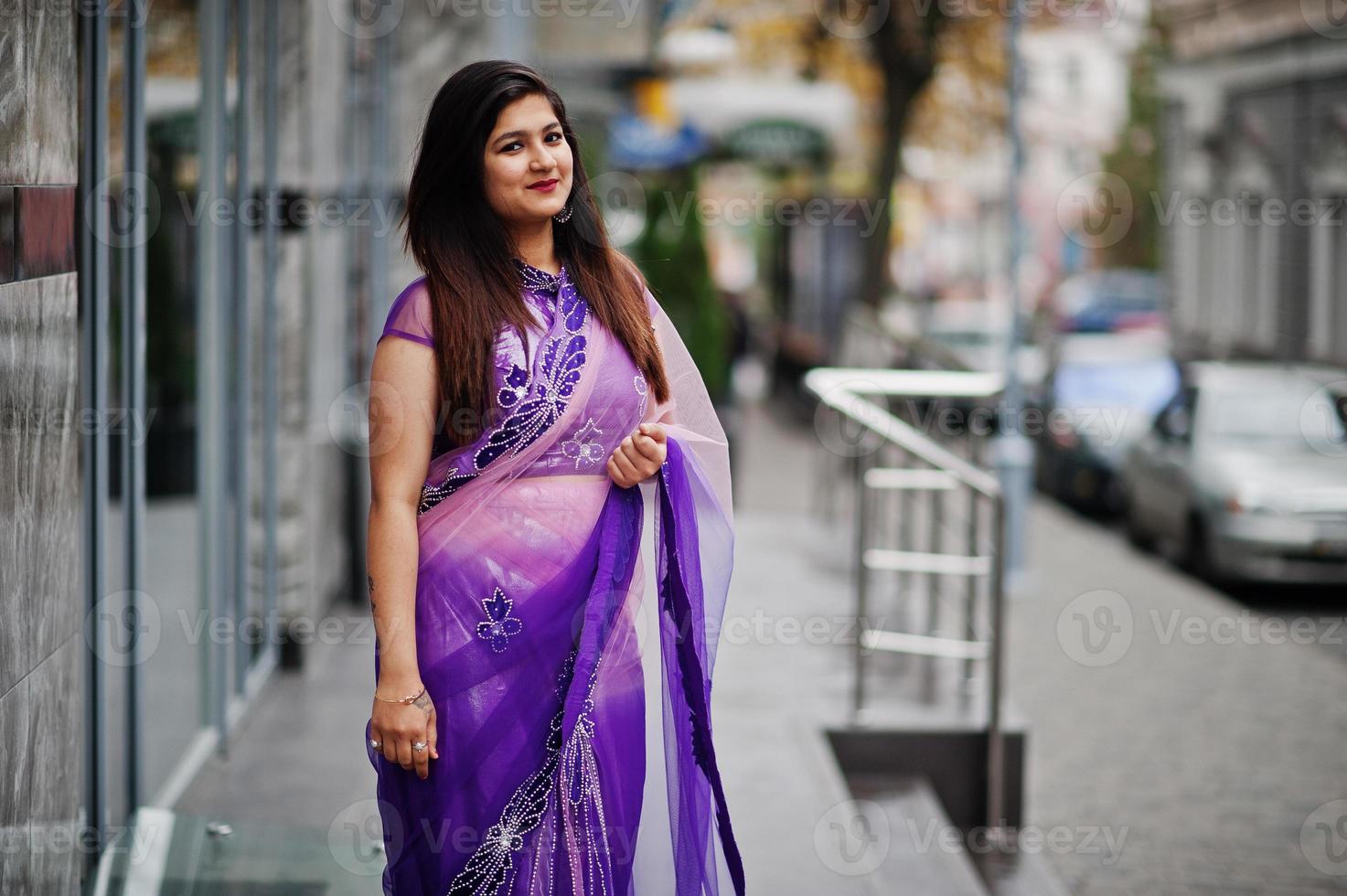 Indian hindu girl at traditional violet saree posed at street. photo