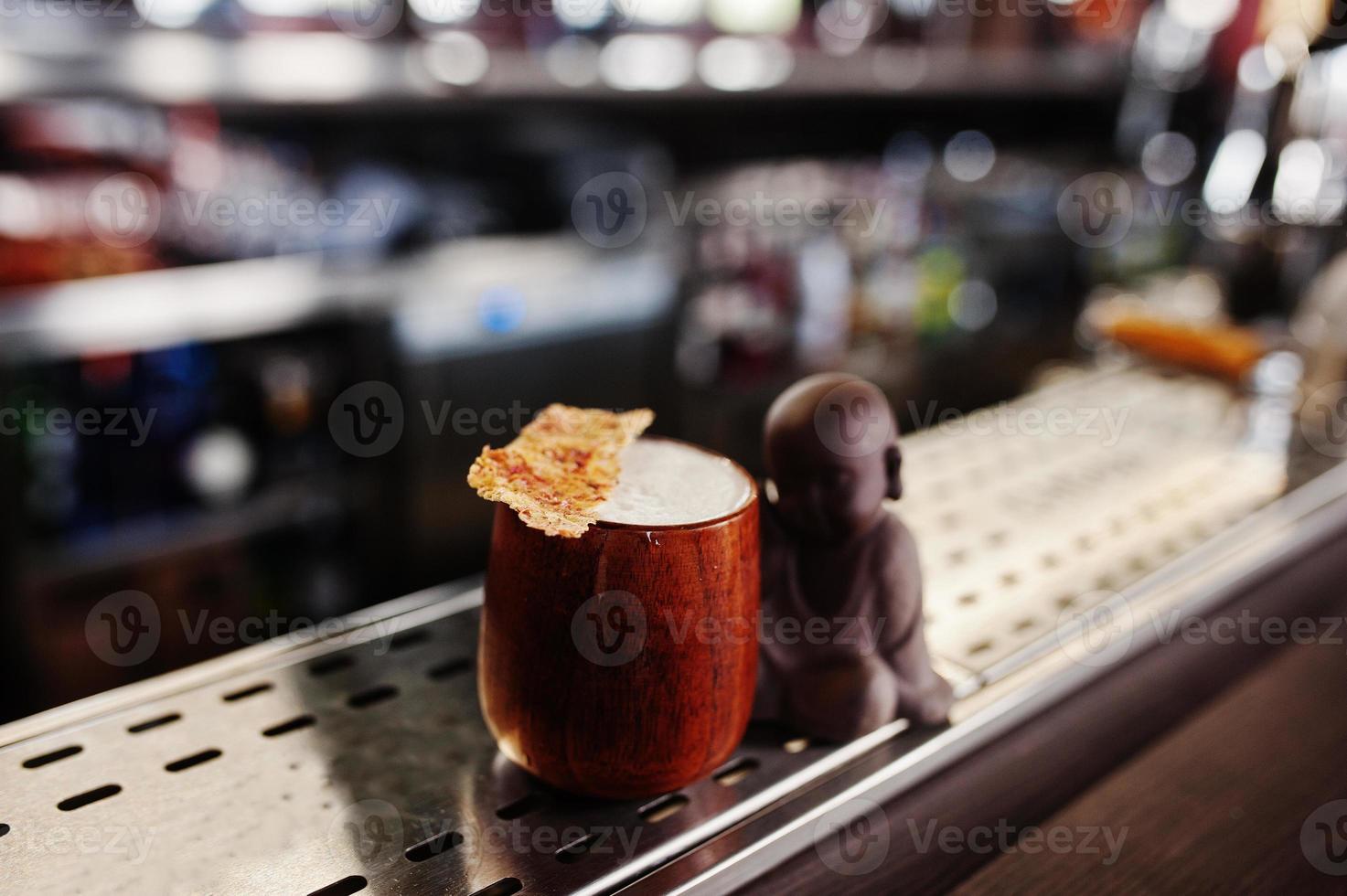Alcoholic cocktail in wooden cup at  bar table. photo